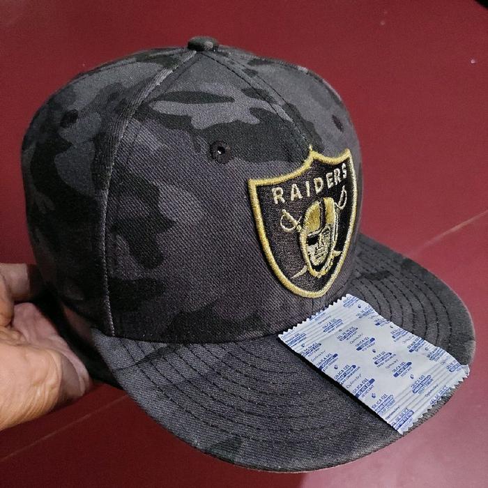 Topi Snapback Logo Raiders dengan motif camo