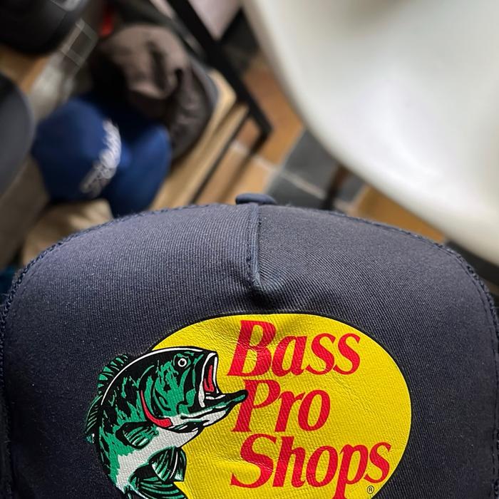 Bass Pro Shops Topi Pancing dengan Logo Ikan Besar dan Desain Kuning Tersedia dalam Warna Navy