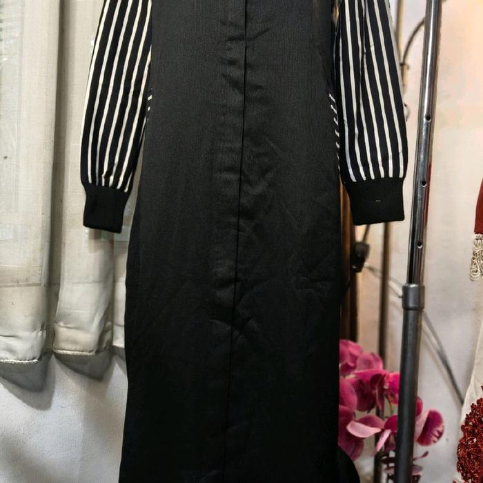 Gamis pada gambar ini termasuk dalam kategori gamis motif garis-garis kombinasi hitam putih dengan d