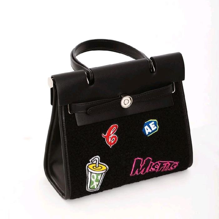 tas tangan kulit dan kanvas hitam gaya Hermes Herbag dengan tambalan bordir Misfits