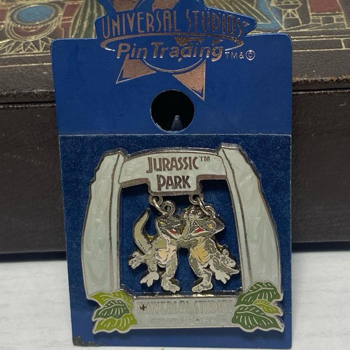 Universal Studios Jurassic Park pin featuring a T-Rex and a sliding gate