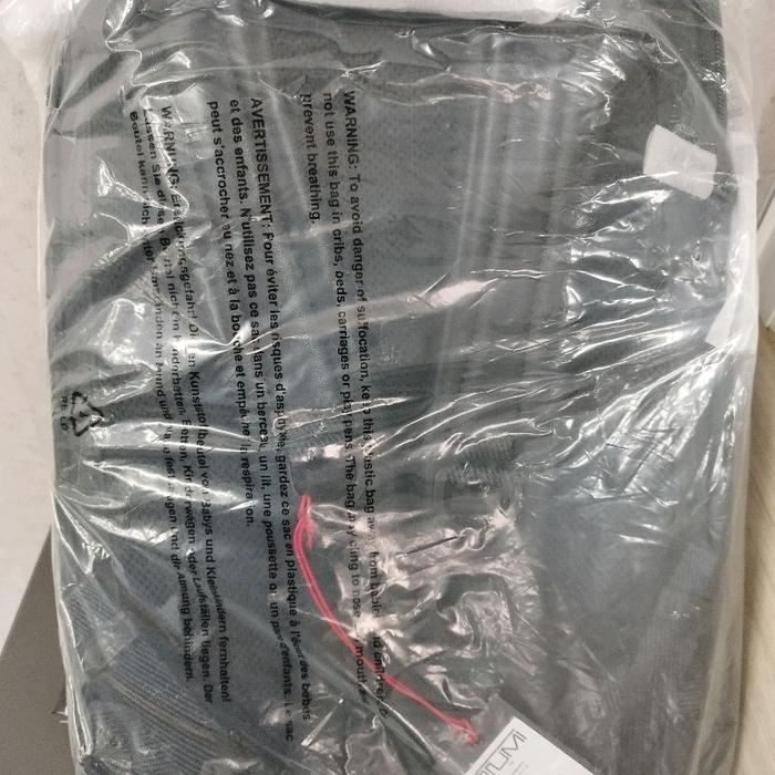 Alva Bravo Tas Tumi Dynamic Backpack - Produk Dalam Kemasan Plastik dengan Tulisan Peringatan