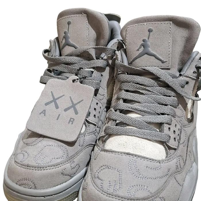 sepatu Nike Air Jordan 4 Retro x KAWS berwarna abu-abu dengan bahan suede.