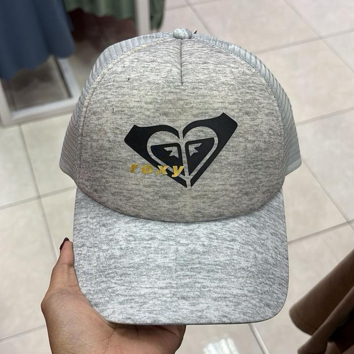 Roxy Topi Ori dengan Logo Hati Hitam dan Tulisan Emas di Depan